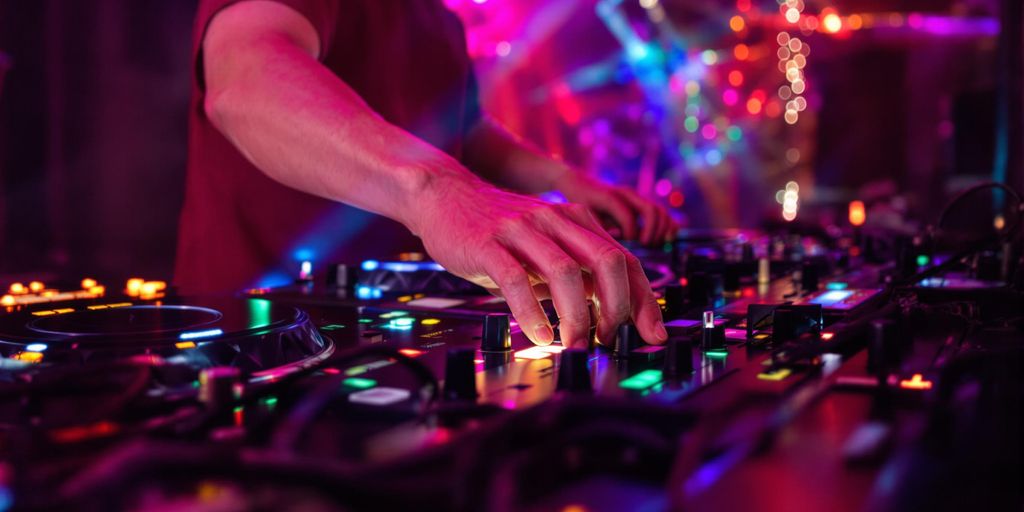 DJ mixing beats with vibrant lights and music equipment.